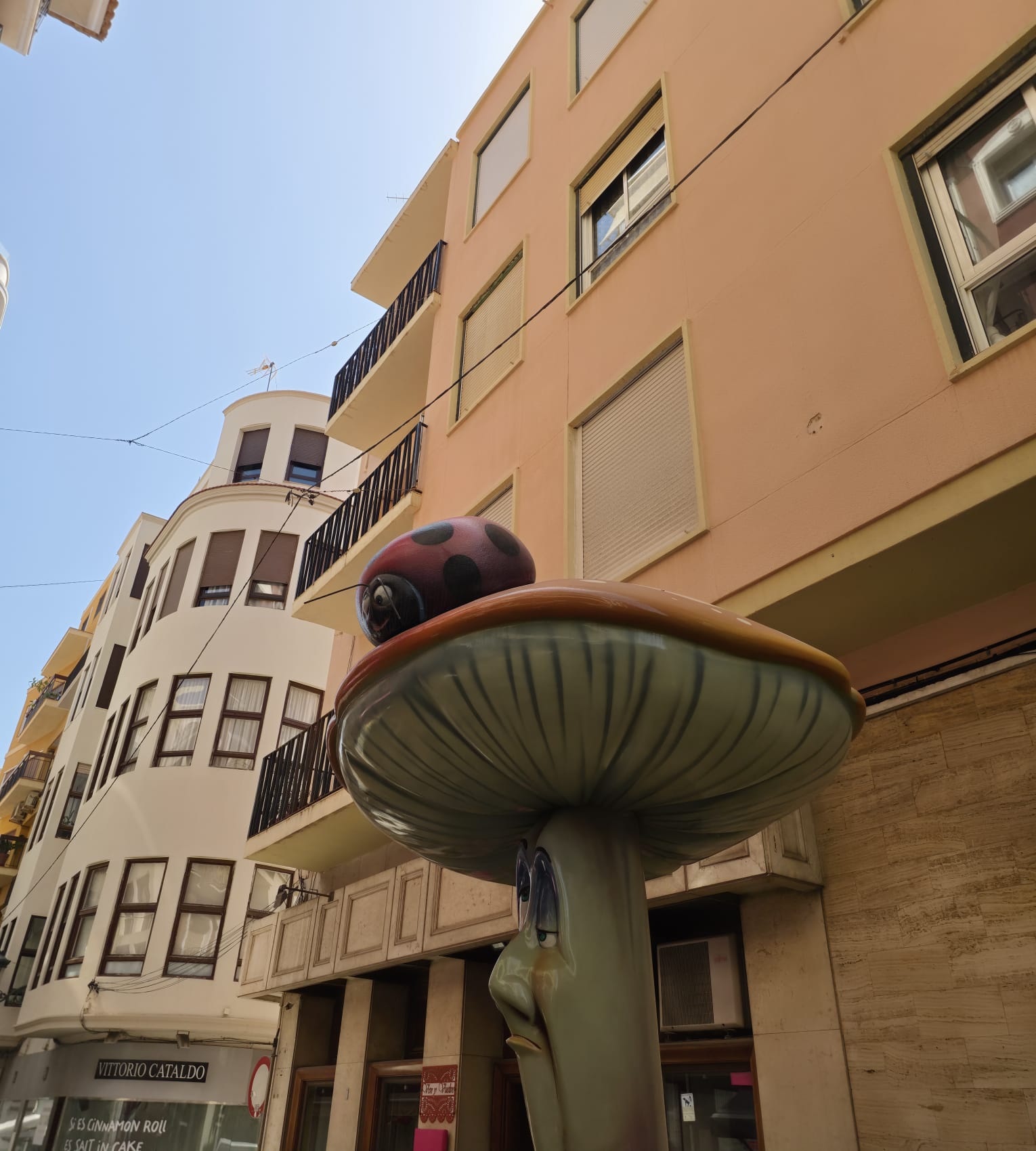 Seta con la mariquita frente al edificio en esquina